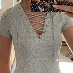 T-shirt - Grå T-shirt med snörning. Knappt använd därför i jättebra skick. Från Bik Bok i storlek XS. 