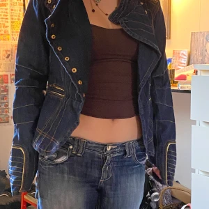 Jeans jacka - En jeans jacka med guldfärgade detaljer. Frakt tillkommer