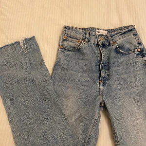 Zara jeans  - Ett par lite croppade jeans från zara i en ljusjeansblå färg storlek 34 bra skick, lite fransiga nertill
