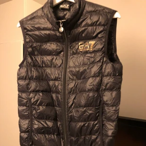 EA7 väst  - tjena. säljer min EA7 väst för jag inte använder den längre. den är i storlek M. Väldigt bra skick, inte använd sen förra sommaren och användes bara ett fåtal gånger. Köpt på room 1006 för 1600kr. påsen medföljer oxå som syns på bilden. skriv om ni är intresserade :)