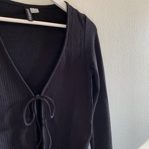 Kytkofta  - Svart ribbad kofta med knytning från hm, storlek S