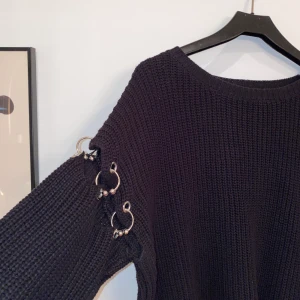 Jätecool stickad tröja från Forever 21 - Svart stickad tröja från forever 21 med metalldetaljer. Knappt använd och därmed i gott skick. Frakt tillkommer.