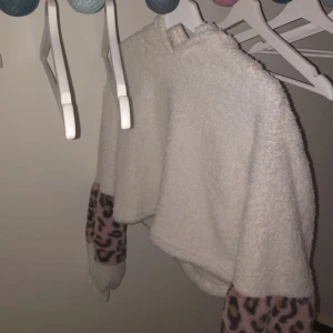 Mjuk leopard hoodie - En vit cropad hoodie med leopard print på armarna. Hoodie är från shein som jag har köpt för typ ett år sen men är knappt använd. Strl s men är ganska cropad. Hör av er för mer information💘