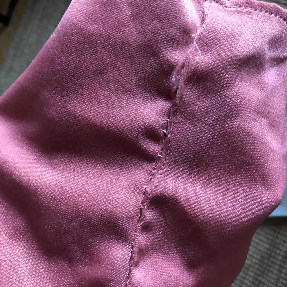 En rosa ”silkes” klänning från Bik bok. Sytt ihop den med vit tråd . Klänningar.