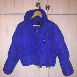  - Jättefin blå vinterjacka som är lite kortare. Den är ganska ”puffig” och har guldiga fina dragkedjor. Ganska hög krage så perfekt på vintern. Använd men fortfarande i bra skick. Frakt tillkommer :)