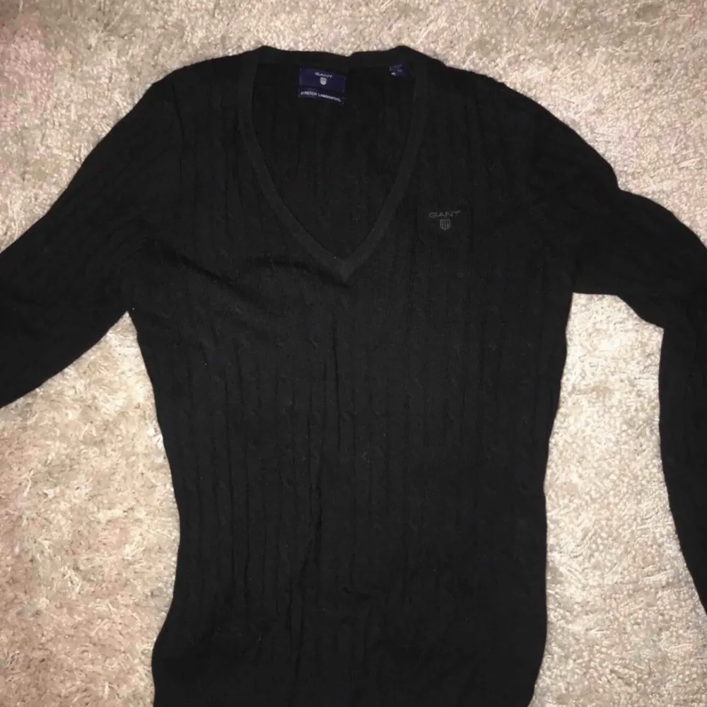 En svart kabelstickad tröja från Gant med v-ringning. Väldigt bra skick. 85% lambwool, 15% nylon. Storlek: M (dam) Nypris: 1299kr. Tröjor & Koftor.