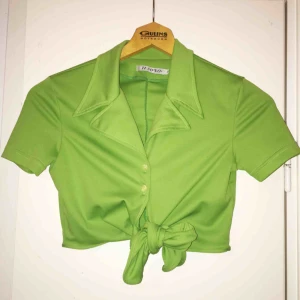  - Knallgrön härlig knyt-topp! Kan knytas fram eller bakom ryggen (om man är smal nog). Märkt S men jag tycker mer den känns som XS. Frakt inkluderat i pris :)