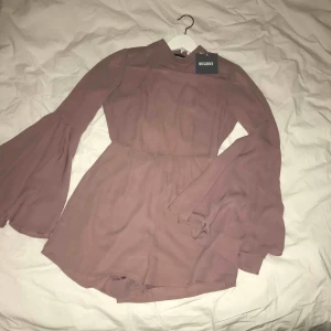  - Mauvefärgad playsuit från missguided, aldrig använd med lapparna kvar! Djup rygg med fin spets som ringar in ryggen. Passar XS-S, även M. 