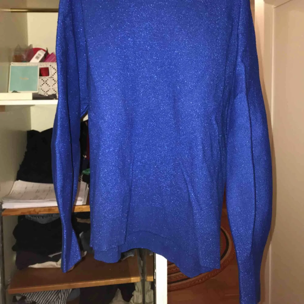Glittrig blå tröja från HM! Dåliga bilder, men den är väldigt fin och skön! Har använt den 3 gånger, så den är inte sliten alls. . Tröjor & Koftor.