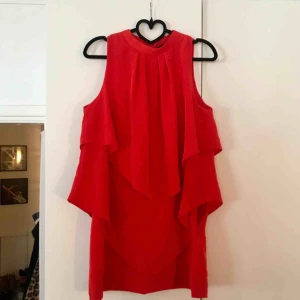 - Röd volangklänning i nyskick. Finns att hämta i Uppsala. Kan även posta, köparen betalar då frakt.