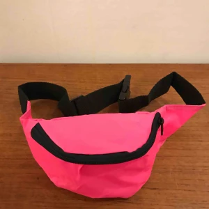  - Magväska i enkel nylon modell från 90-talet.  Har ett litet parti med denna rosa neon färg och även svart och mörkblå. 