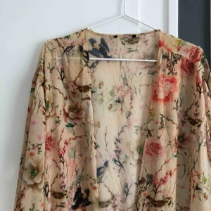  - Öppen tunika i tunt material med fransar. Minns ej vart den kommer ifrån då lappen är bortklippt. Ett pyttelitet hål precis där lappen suttit. Möts upp i Sthlm eller skickar mot fraktkostnad 