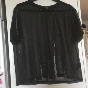 Svartglittrig mesh topp stl m  - Svart mesh topp som glittrar i silver. 
