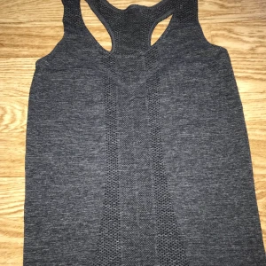 Grått tränningslinne  - Tränningslinne i grått som aldrig använts. 