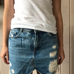 Jeanskjol Zara - Snygg kjol med slitningar från Zara. Endast använd ett fåtal gånger, så den är som ny! Det är en bra längd på kjolen, jag som bär den är 161 CM. 100 kr + frakt 