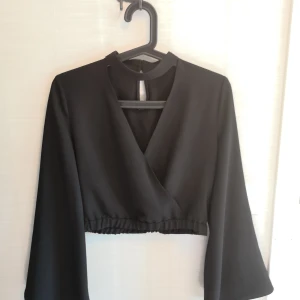 Svart Croptop med trumpetärmar strl S - Säljer en superfin svart croptop med trumpetärmar. Knappt använd, så superfint skick. Lappen med material är bortklippt. Storlek Small. Pris 100kr inkl frakt! Samfraktar, så kolla gärna in mina andra annonser så blir det billigare!! 