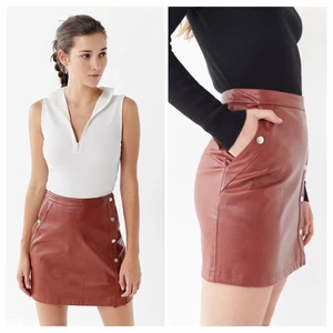 Skinnkjol Urban Outfitters  - Tegelröd kjol i realistisk skinnimitation i jättefin kvalitet från Urban Outfitters. Jag lånar bild då det är svårt att fånga modellen på bild! Endast använd en gång och kostade ca 500kr i nypris. Storlek medium, 200kr. 