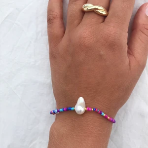 Färgglatt armband med sötvattenspärla - En favorit! Ett handgjort, färgglatt armband med en stor sötvattenspärla och guldfärgade detaljer.🥺