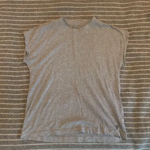 Tränings t-Shirt, grå, strl M - T-Shirt som funkar bra till både träning och vardaglig tröja. Köpt på Intersport i år och använd ca 3 ggr. Mycket bra skick och god passform.