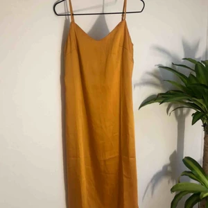  - Gul klänning i silkesmaterial, aldrig använd 