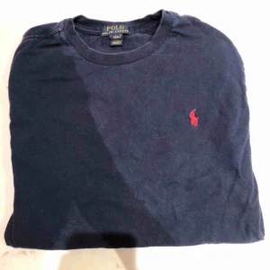  - En polo T-shirt, väldigt enkel design med den polo-märket på bröstet. Storlek L för kids så skulle säga S - Xs för äldre. Kunden står för frakten :) 