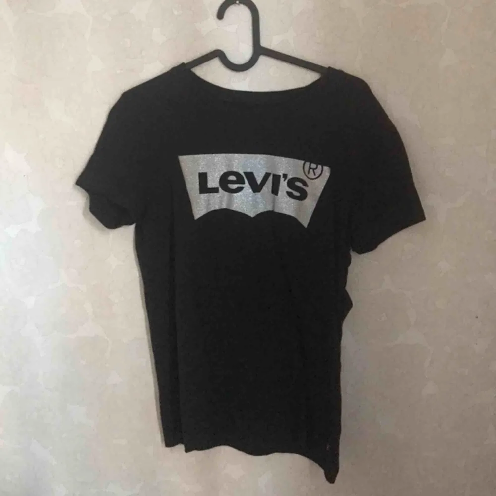 Svart Levis T-shirt med glittrigt tryck i storlek S. Knappt använd 🌟 köparen står för frakt 😊. T-shirts.