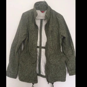  - Cargojacka i grönt med svagt leomönster och dragsko i midjan. Köparen står för frakten✨