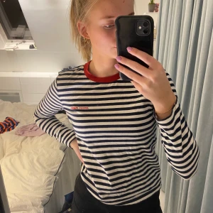 Långärmad tröja från &othetstories - Jättefin randig långärmad tröja från &otherstories i storlek xs. Jag skulle säga att den passar xs/s. Den är vit/mörkblå randig med en röd text på bröstet och rött tyg vid halsen. Köpte den förra året men har knappt kommit till användning. Finns inte kvar att köpa i affär.