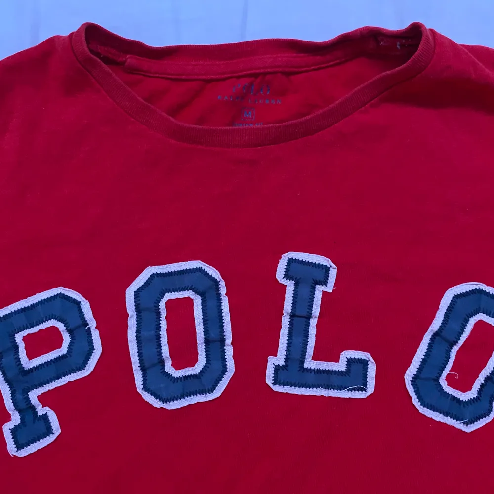 Röd t tröja polo med fin text storlek m fin färg 300kr. T-shirts.