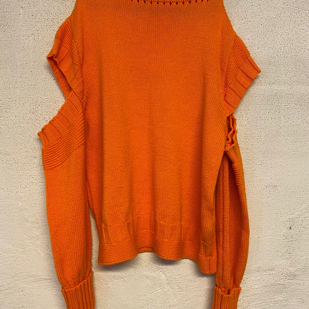 Stickad tröja ifrån Gina Tricot. Stark orange färg i verkligheten och har öppna detaljer på armarna. Är i mycket fint skick och kommer i storlek M. Köparen står för frakten. Stickat.