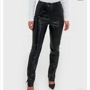 Skinnbyxor med split i storlek 40 - Högmidjade skinnbyxor med split, storlek 40 men ingen stretch så passar 38 