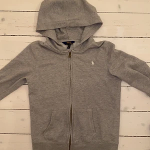 Ralph Lauren  - Ralph Lauren Kofta i ljusgrått. Använt den ett par få gånger och den är i bra skick! Koftan är köpt i största barnstorleken (16 år). Men passar även bra på mig som har vuxen storlek S. Skulle säga att koftan är i storlek XS. Köpare står för frakt❗️