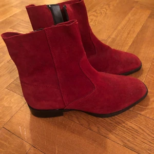 Röda oanvända mockaskor  - Röda boots i mocka, helt oanvända. Storlek 38. 