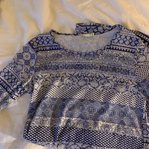 Vit och blå mönstrad klänning Nelly  - Klänning från Nelly använd 1 gång. Är under knäna på mig som är 171 lång. Ärmarna är trekvart.💕