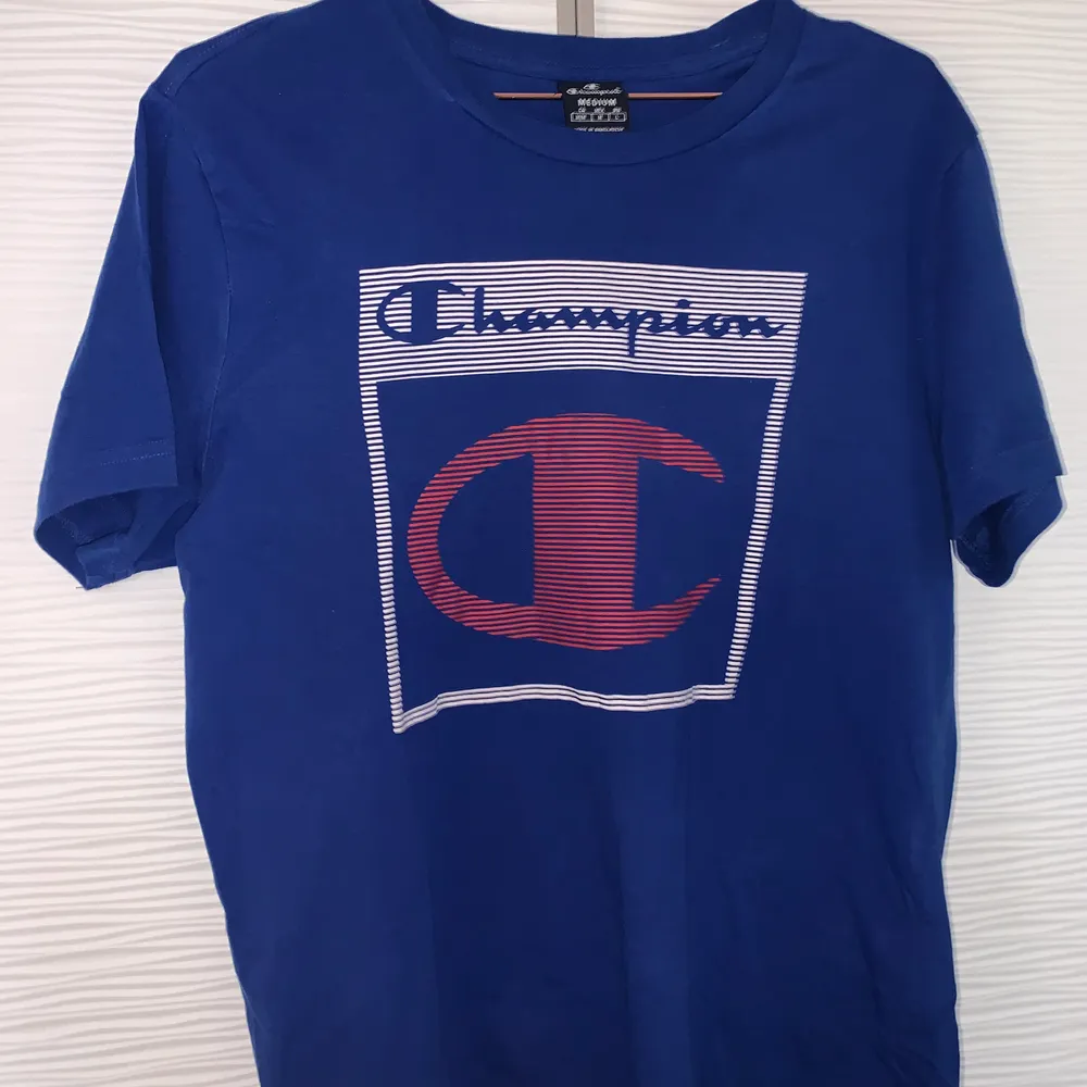 En fin blå T-shirt från Champion. Knappt använd så är det ny och är i storlek M🥰 köparen står för frakten, 60 kr och bara skicka om du vill ha fler bilder! . T-shirts.