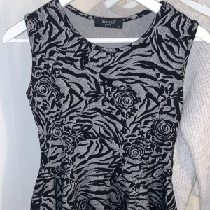 Topp med volang  - Säljer en svart grå topp med volang i nedre delen. Toppen är endast använd fåtal gånger. Köparen står för frakten. 