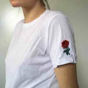  - Säljer en supersnygg vit t-shirt med en ros broderad på ena axeln. Köpt på Brandy Melville i London. Kan mötas upp i Örebro eller så tillkommer en fraktkostnad på 59kr. Priset kan alltid diskuteras :-)