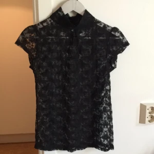  - Turtleneck spets-topp med fjärilar, knäppning bak.