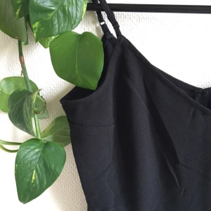  - Svart jumpsuit med öppen rygg. Oanvänd. Tight modell upptill med vida ben. Har en dold dragkedja i midjan. 