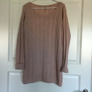  - En gammelrosa stickad oversize tröja. 
