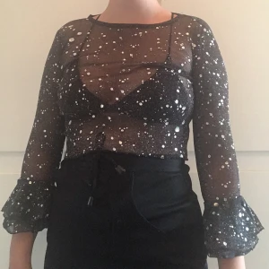 Glitter topp - Sjukt snygg genomskinlig topp med silvriga prickar på, slutar lite över naveln. Stl 34 elr liten 36