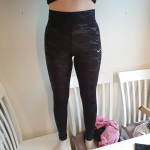 Nike byxor - Snygga träningsbyxor stretchiga. Väl använda. Köpare står för frakt eller upphängning. Stl. S men skklle säga att den är mer en xs. Millitärmönster i svart, lite slitet runt knäna.