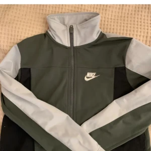 NIKE TRÖJA - En jättesnygg mörkgrön/grå tracktop tröja, köpte den men den var alldeles var för liten:( 