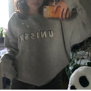 grå sweatshirt  - en grå sweatshirt med trycket ”unisex”