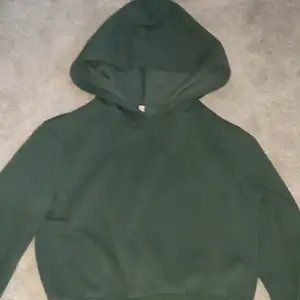 säljer denna mörkgråa hoodie i storleken s, det är en hoodie som slutar vid naveln