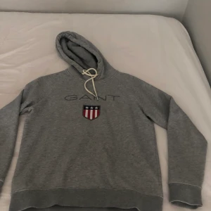 Hoodie  - Jag säljer min ljusgrå hoodie från Gant! Säljer för att den har blivit förliten ! Köparen står för frakt < 3 