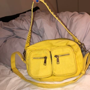 Noella bag, gul - Aldrig använd pga att det inte riktigt är min stil. Väskan är i ett matrial som påminner om en blandning av jeans och tyg. Köpt för 679 kr, säljer för 200 kr inklusive frakt. 