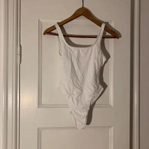 Vit baddräkt  - Vit oanvänd baddräkt från ASOS. Väldigt djup i ryggen och går högt upp på höfterna! säljes pga för liten. Står storlek 36 på lappen men skulle absolut säga att det är storlek XS