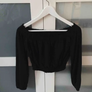  - En svart off shoulder tröja med ”töjbara” gummiband vid sömmarna. En aning pösig, men gummibanden gör att den sitter åt.