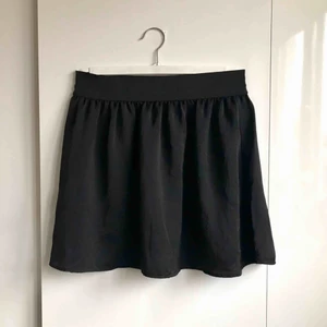  - > INKL FRAKT 60kr <   Svart kjol i något glansigare material. Skickas till dig för 60kr! 